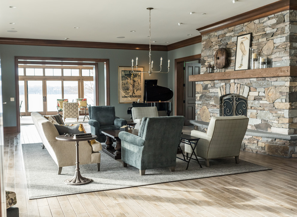 Aménagement d'un salon classique fermé avec une salle de réception, un mur bleu, parquet clair, une cheminée standard, un manteau de cheminée en pierre et un sol marron.