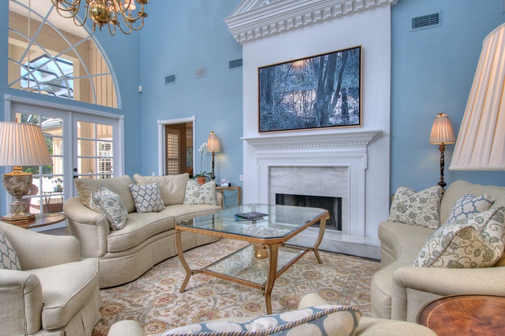 На фото: парадная гостиная комната в классическом стиле с синими стенами, стандартным камином, фасадом камина из штукатурки и ковром на полу с