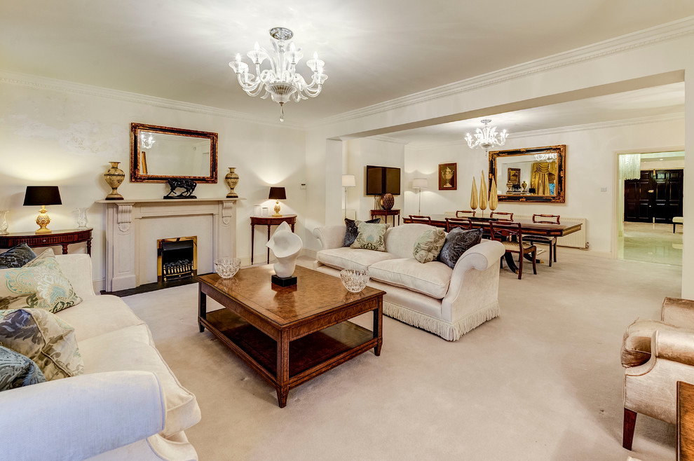 Repräsentatives, Fernseherloses, Offenes Klassisches Wohnzimmer mit beiger Wandfarbe, Teppichboden und Kamin in London