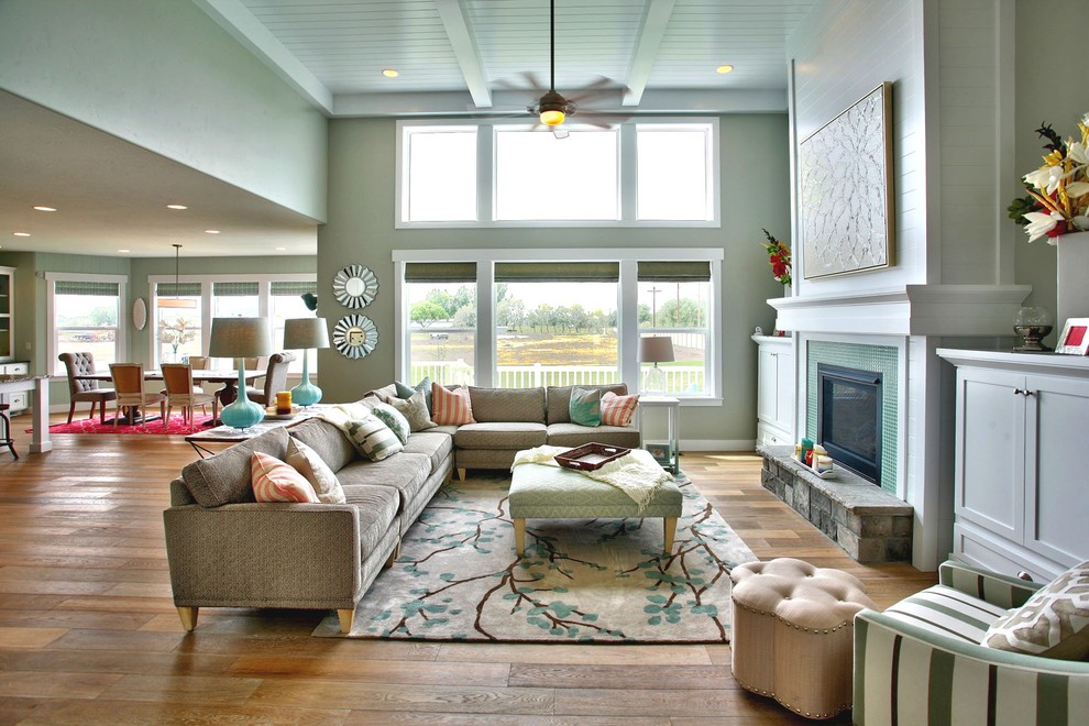 На фото: открытая гостиная комната в классическом стиле с зелеными стенами и стандартным камином без телевизора