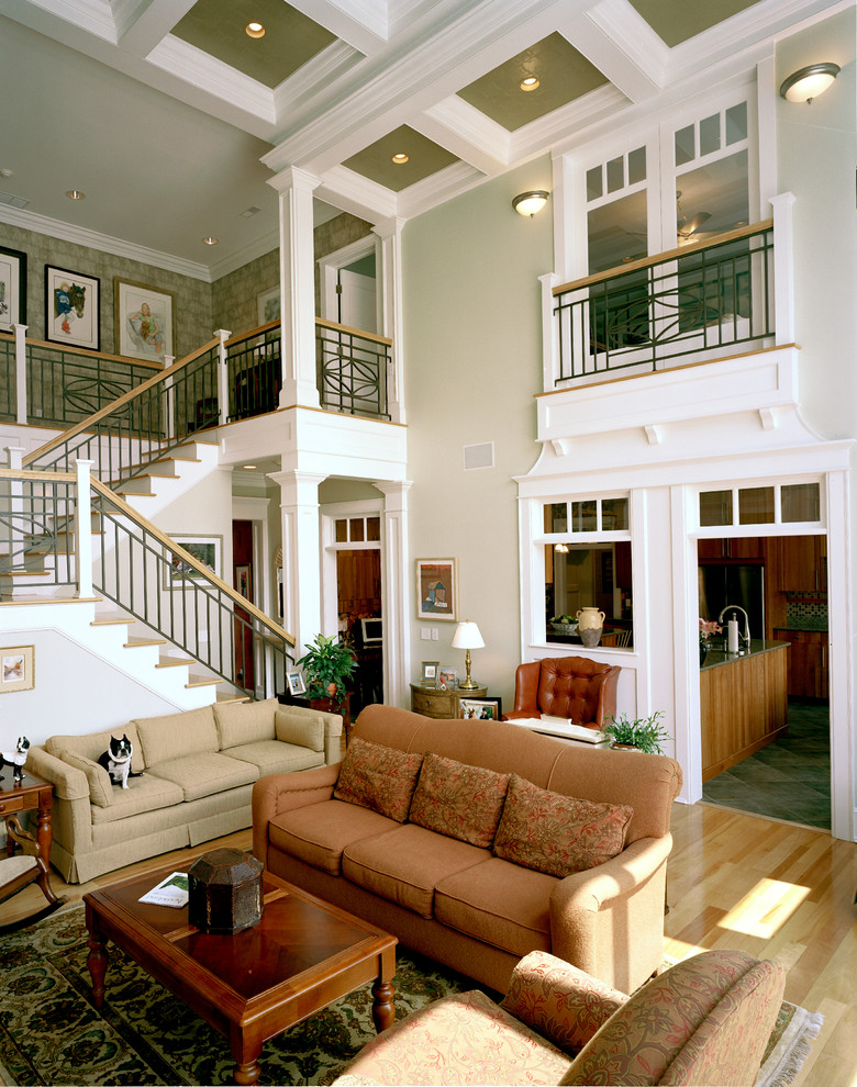Cette image montre un grand salon traditionnel avec un mur vert et un escalier.