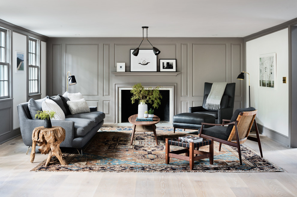 Aménagement d'un salon gris et noir classique fermé avec un mur gris, parquet clair, une cheminée standard et éclairage.