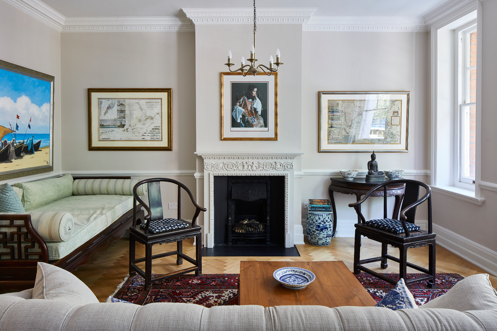 Aménagement d'un salon classique avec un mur gris, un sol en bois brun, une cheminée standard et un sol marron.
