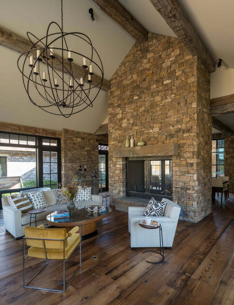Rustic living room in Other with a two-sided fireplace.
