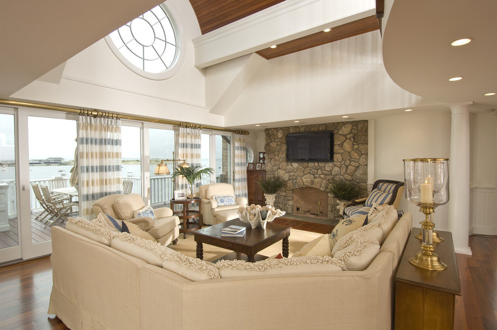 Стильный дизайн: гостиная комната в классическом стиле с стандартным камином, фасадом камина из камня и телевизором на стене - последний тренд