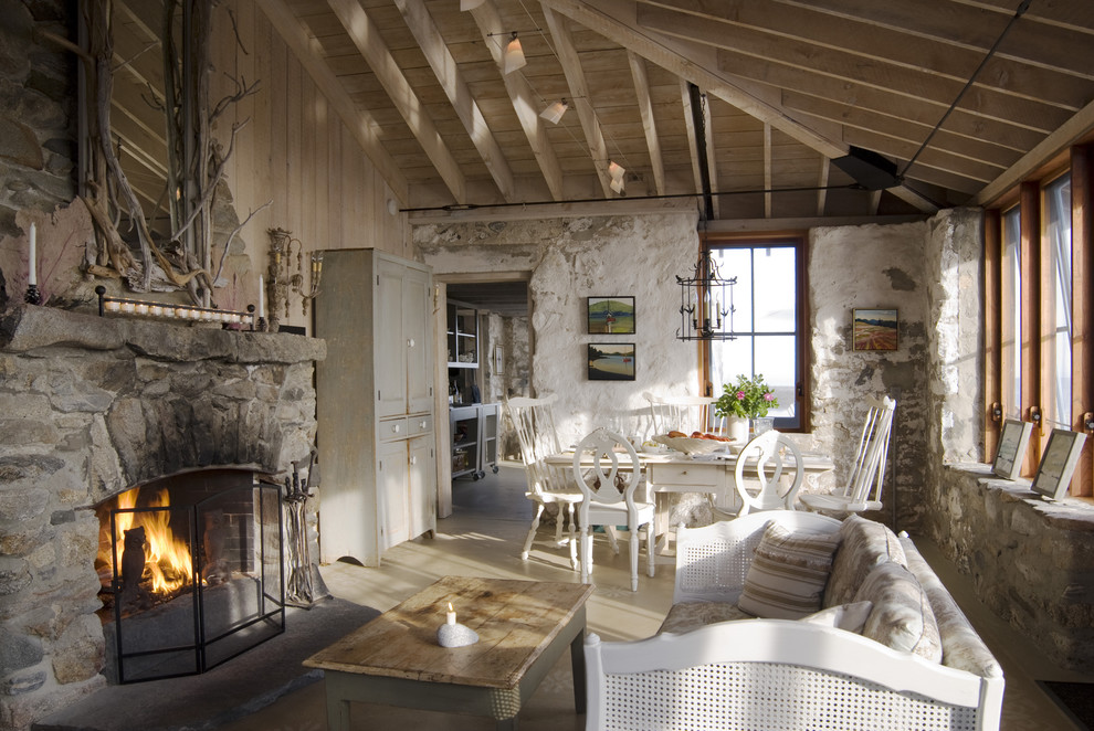 Idée de décoration pour un salon champêtre avec sol en béton ciré et un manteau de cheminée en pierre.