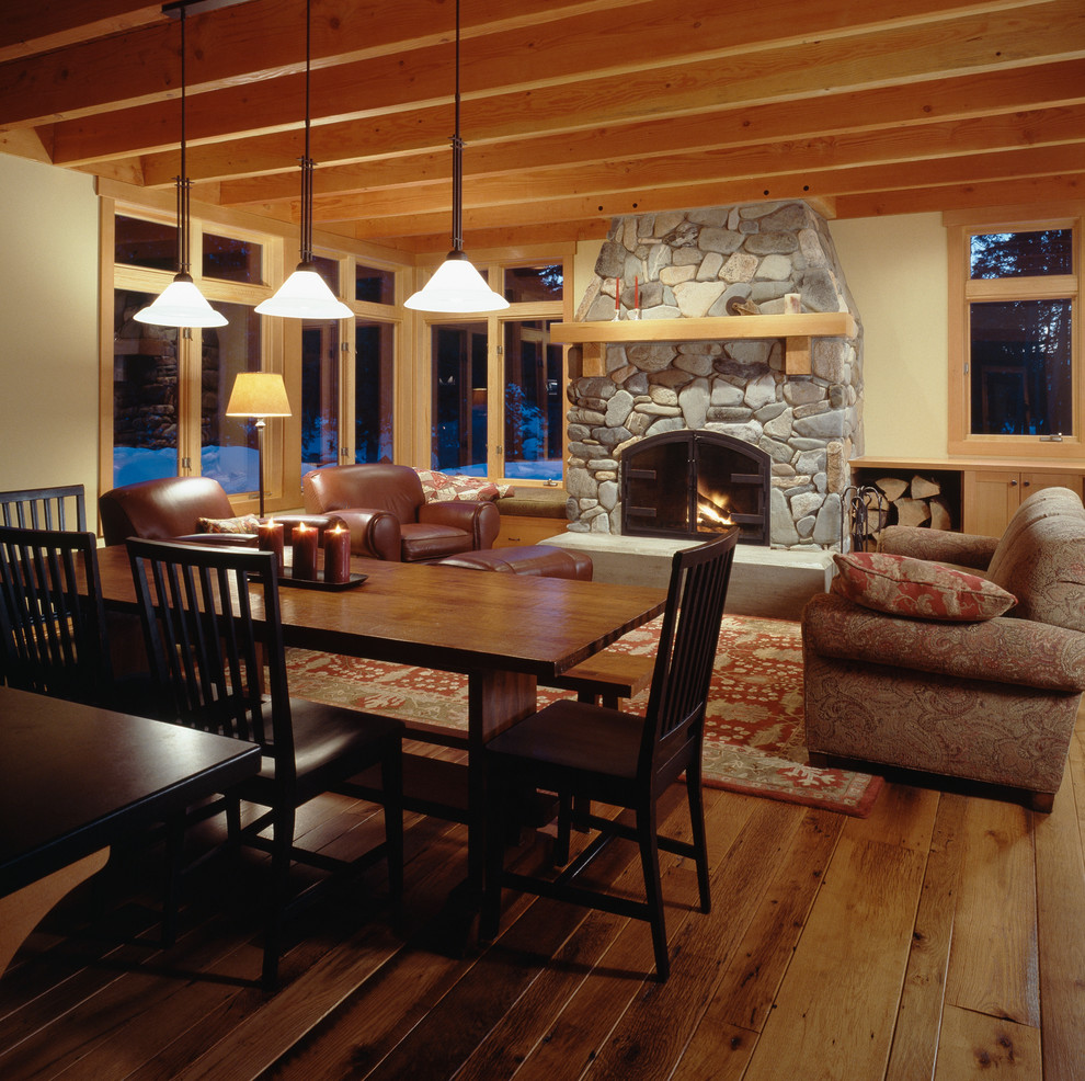 Idée de décoration pour un salon tradition avec un mur beige, un sol en bois brun, une cheminée standard, un manteau de cheminée en pierre et éclairage.