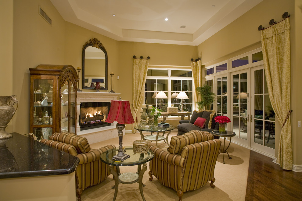 Пример оригинального дизайна: гостиная комната в классическом стиле с желтыми стенами, угловым камином и красивыми шторами без телевизора