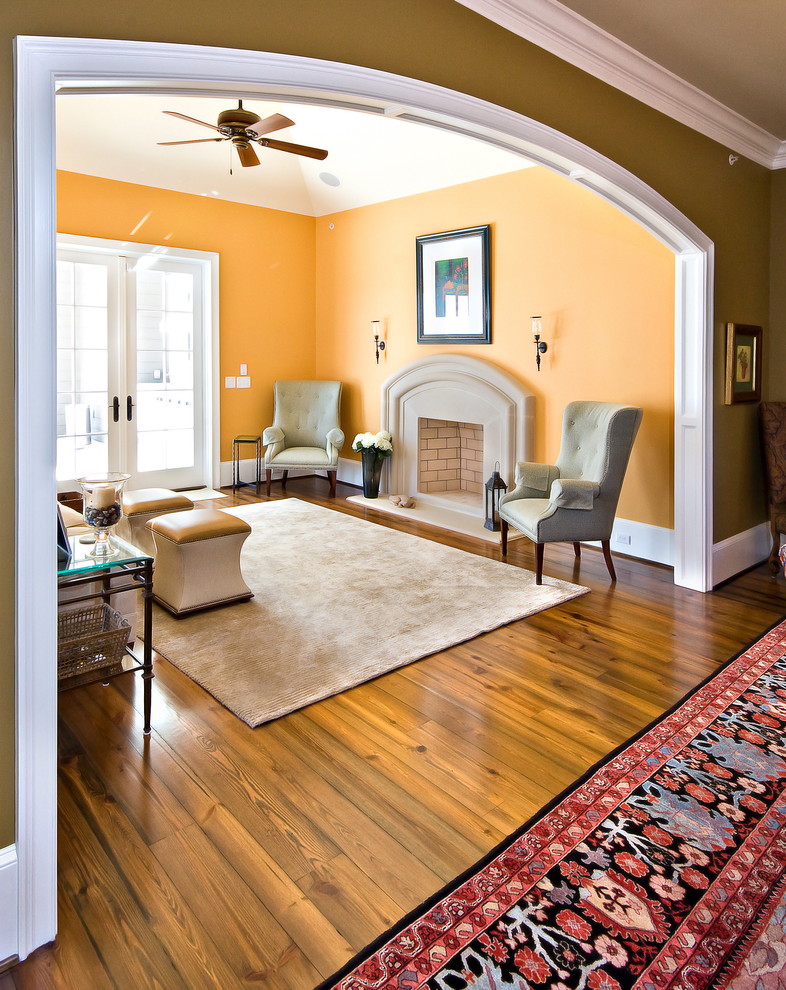 Modelo de salón clásico con parades naranjas y alfombra