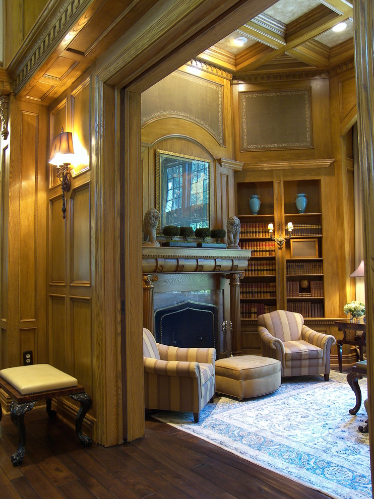 Exemple d'un grand salon chic fermé avec une bibliothèque ou un coin lecture, un mur marron, parquet foncé, un manteau de cheminée en pierre et un téléviseur encastré.