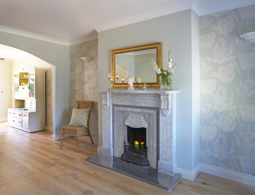 Foto de salón clásico con paredes azules, suelo de madera clara y todas las chimeneas