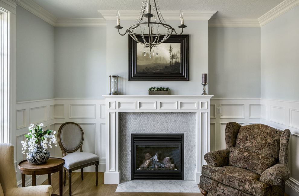 Стильный дизайн: гостиная комната в классическом стиле с серыми стенами и фасадом камина из плитки - последний тренд