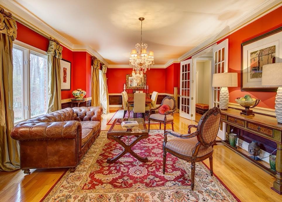 Пример оригинального дизайна: большая парадная, открытая гостиная комната в классическом стиле с красными стенами и светлым паркетным полом без телевизора