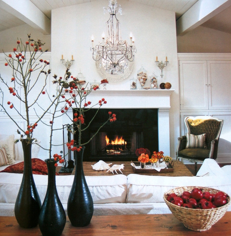 Example of a classic living room design in Orange County with white walls and a standard fireplace