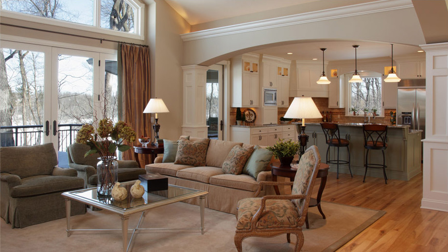 Idée de décoration pour un très grand salon tradition ouvert avec une salle de réception, un sol en bois brun et un mur beige.