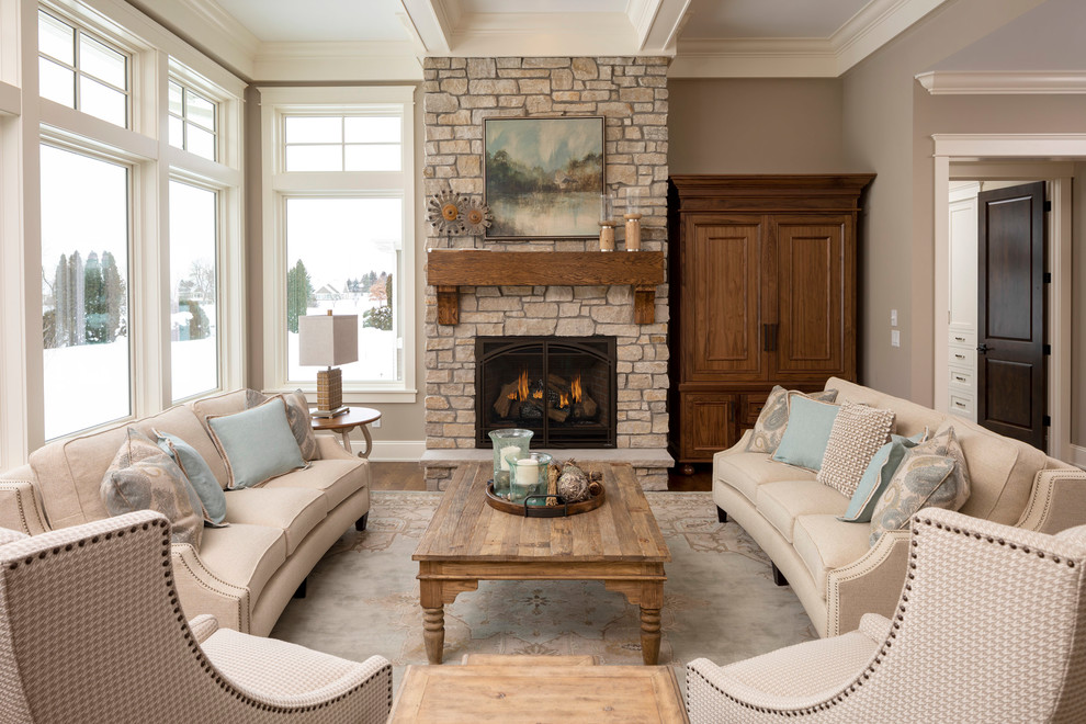 Aménagement d'un salon classique avec une salle de réception, un mur beige, un sol en bois brun, une cheminée standard, un manteau de cheminée en pierre, un téléviseur dissimulé et un sol bleu.