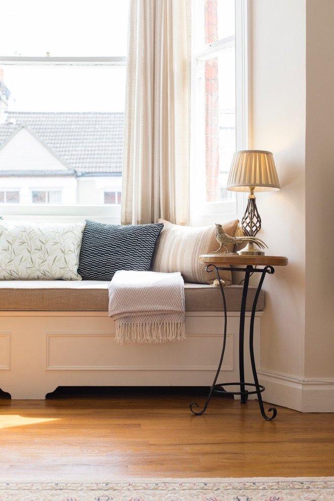 Immagine di un soggiorno chic di medie dimensioni e aperto con pareti beige e pavimento in legno massello medio