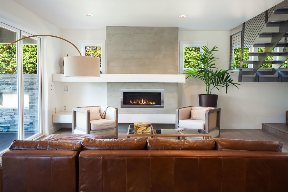 Inspiration pour un salon design avec un mur beige, un sol en bois brun, une cheminée ribbon et éclairage.