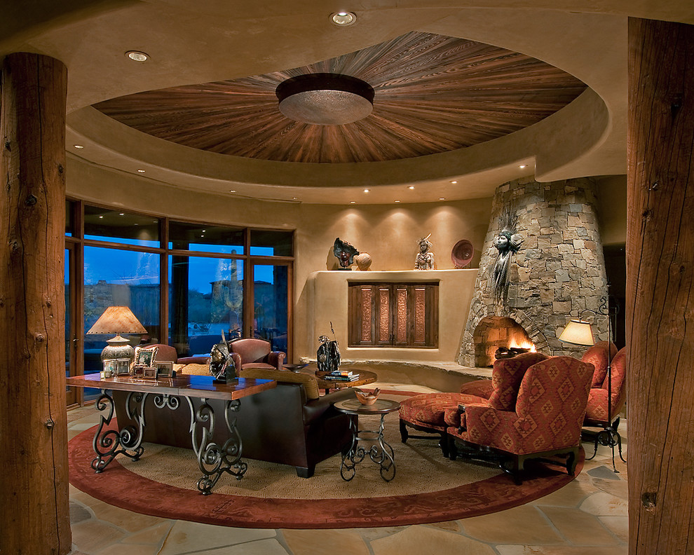 フェニックスにある高級な広いサンタフェスタイルのおしゃれなリビング (ベージュの壁、石材の暖炉まわり、コーナー設置型暖炉、内蔵型テレビ) の写真