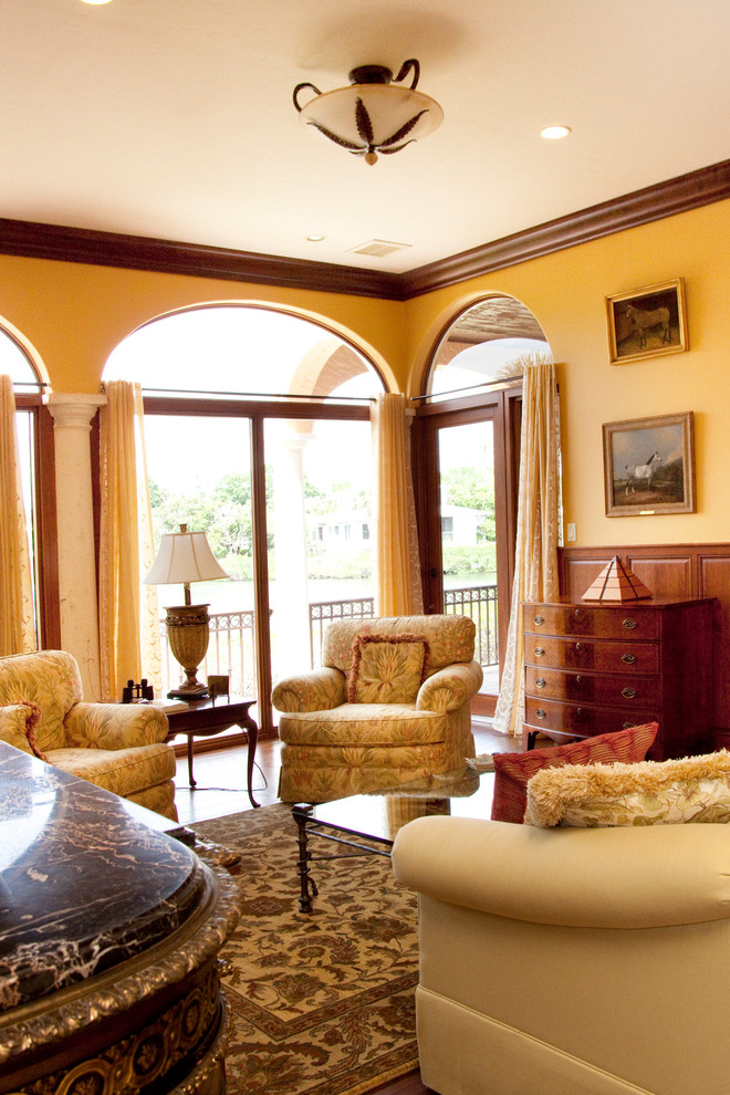 Идея дизайна: парадная, открытая гостиная комната среднего размера в классическом стиле с желтыми стенами, стандартным камином, фасадом камина из камня и паркетным полом среднего тона