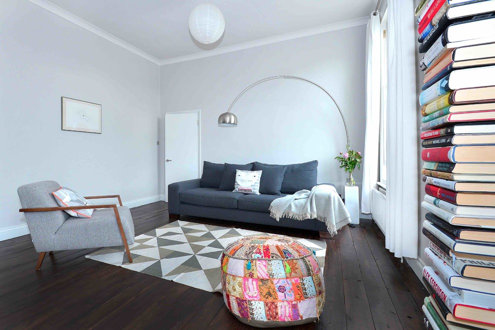 Идея дизайна: открытая гостиная комната среднего размера в классическом стиле с серыми стенами, темным паркетным полом, стандартным камином и фасадом камина из штукатурки