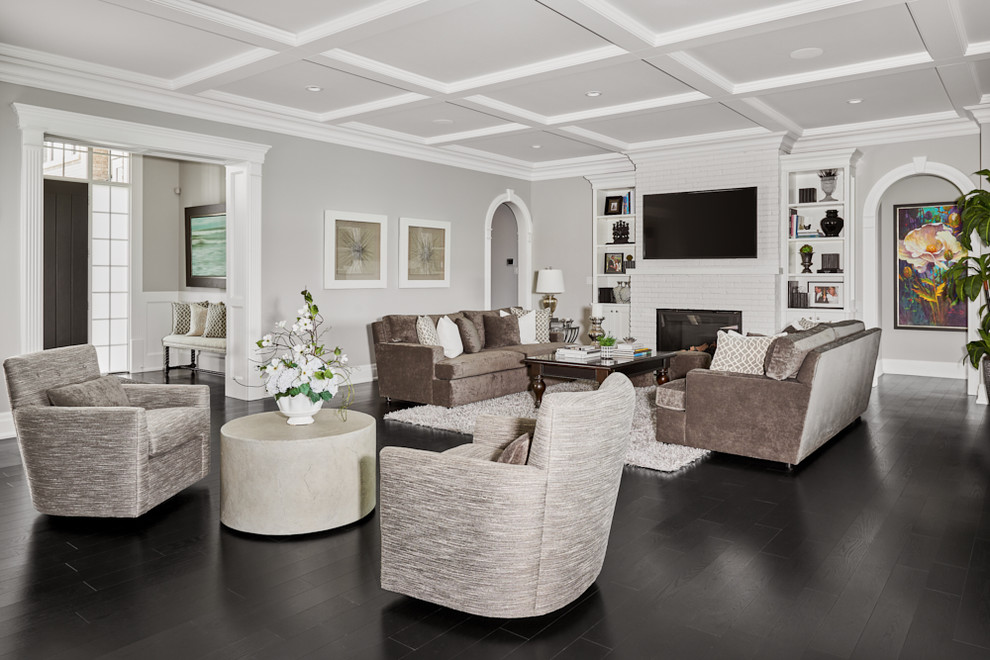 Immagine di un grande soggiorno tradizionale aperto con pareti bianche, parquet scuro, camino classico, cornice del camino in mattoni e TV a parete