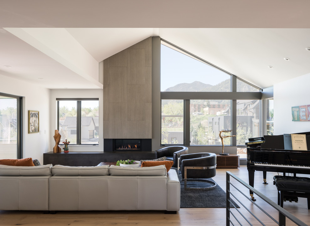 Esempio di un soggiorno design di medie dimensioni e aperto con pareti bianche, pavimento in legno massello medio e pavimento marrone