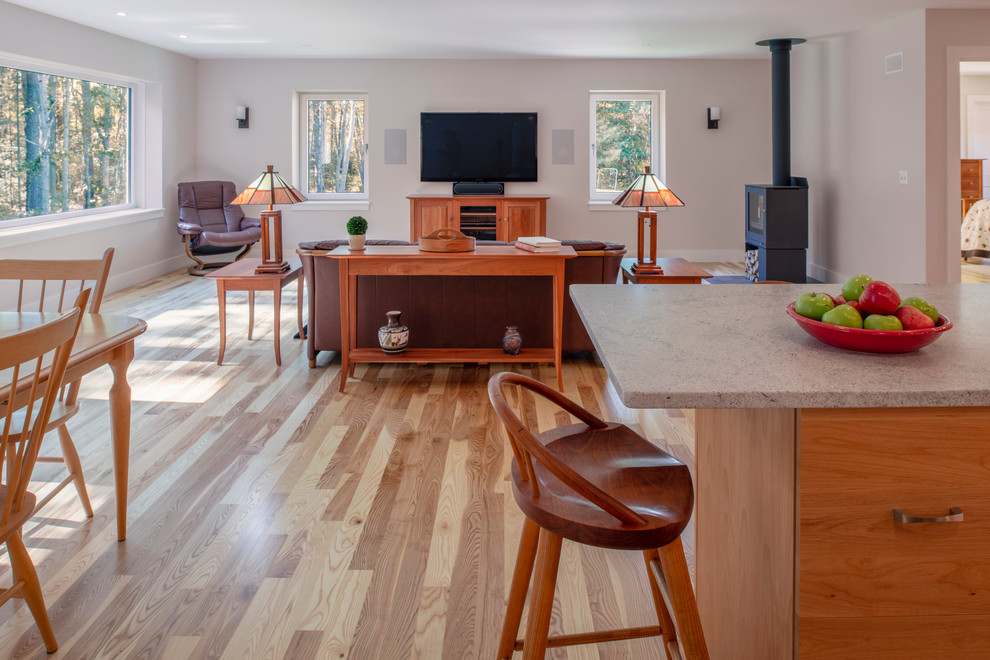 Immagine di un grande soggiorno minimalista aperto con pareti rosa, pavimento in legno massello medio, stufa a legna, TV a parete e pavimento beige