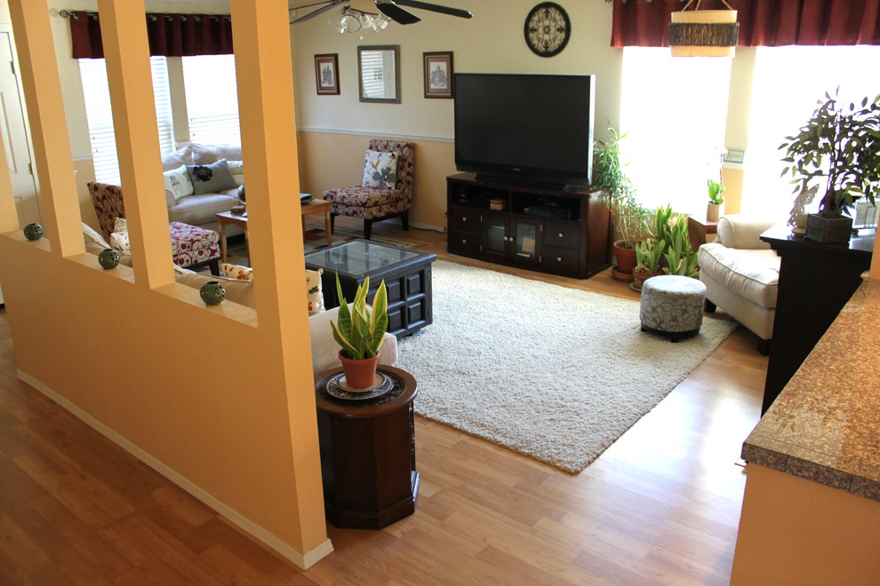 Источник вдохновения для домашнего уюта: гостиная комната в современном стиле с желтыми стенами и полом из ламината