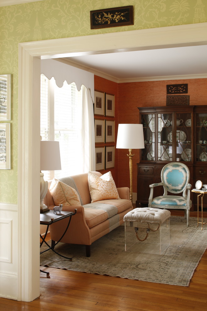 Imagen de salón para visitas clásico con parades naranjas y suelo de madera clara