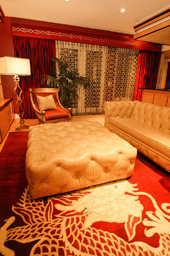 Imagen de salón para visitas abierto actual de tamaño medio sin chimenea con paredes rojas, suelo de madera clara y pared multimedia