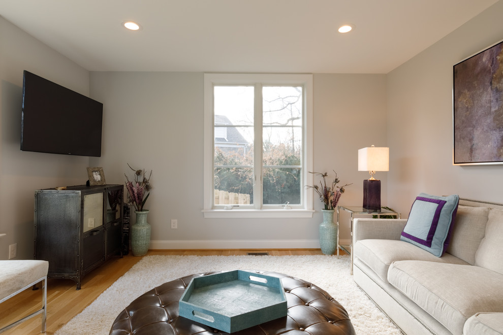 Immagine di un soggiorno tradizionale chiuso con pareti blu, pavimento in legno massello medio, TV a parete e pavimento marrone