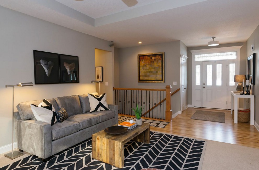 Immagine di un soggiorno chic di medie dimensioni con pareti grigie, pavimento in legno massello medio e nessun camino