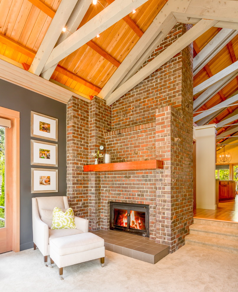 Aménagement d'un grand salon classique ouvert avec un mur gris, moquette, une cheminée standard et un manteau de cheminée en brique.