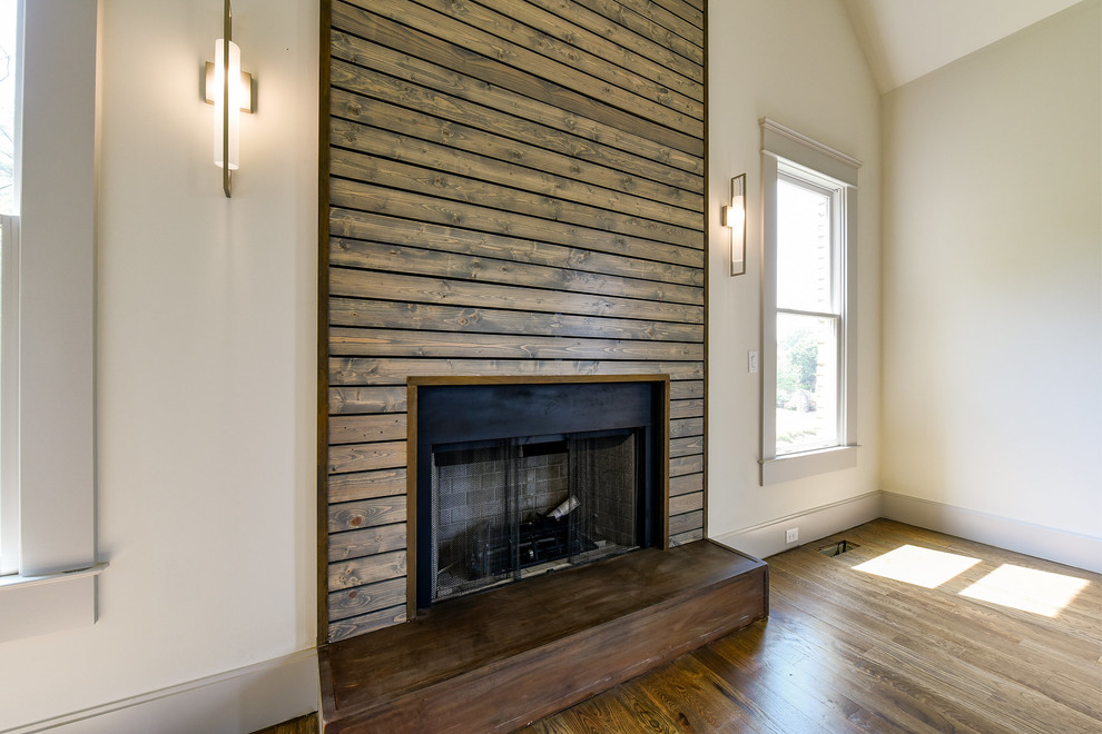 Großes, Fernseherloses Klassisches Wohnzimmer mit weißer Wandfarbe, braunem Holzboden, Kamin und Kaminumrandung aus Holz in Atlanta