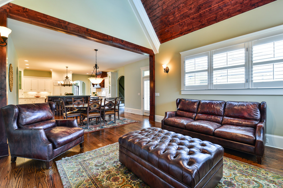 Mittelgroßes, Abgetrenntes Klassisches Wohnzimmer mit grüner Wandfarbe, dunklem Holzboden, Kamin, Kaminumrandung aus Stein und TV-Wand in Atlanta