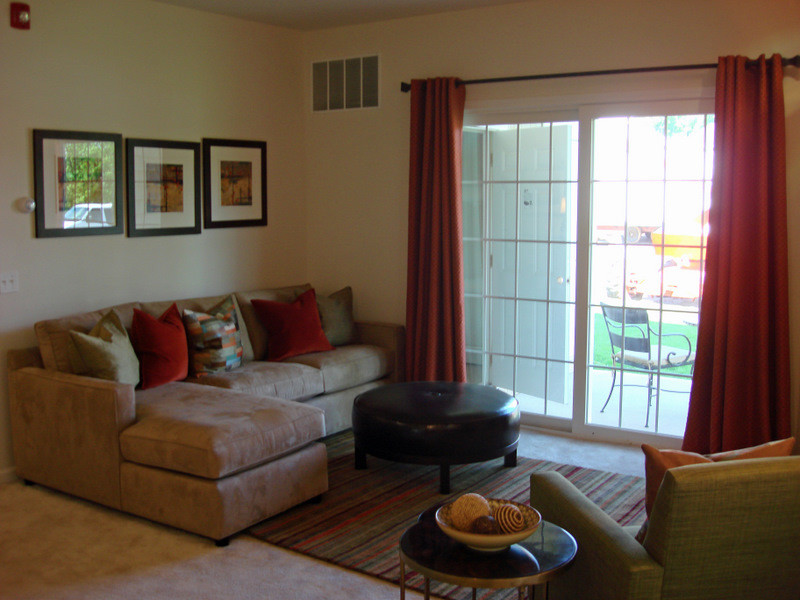Small classic open plan living room with yellow walls, carpet, a wall mounted tv and brown floors.