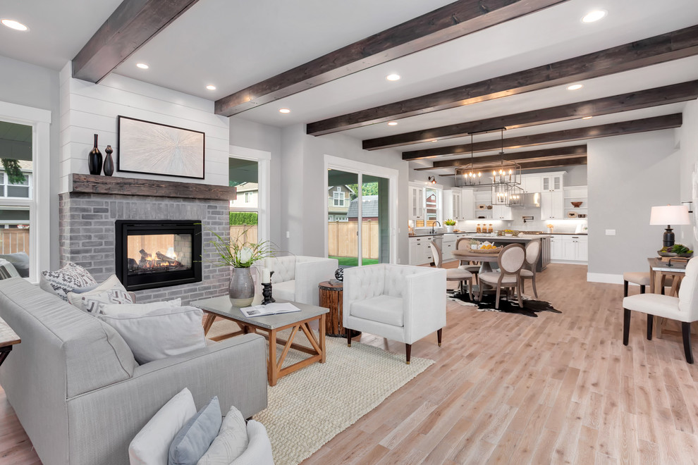Photo of a medium sized contemporary formal open plan living room in Seattle with light hardwood flooring, a standard fireplace and a brick fireplace surround.
