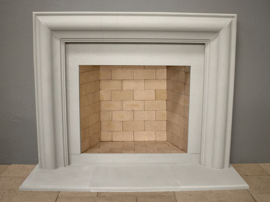 Immagine di un soggiorno tradizionale di medie dimensioni con pareti grigie, pavimento in travertino, camino classico, cornice del camino in pietra e pavimento beige