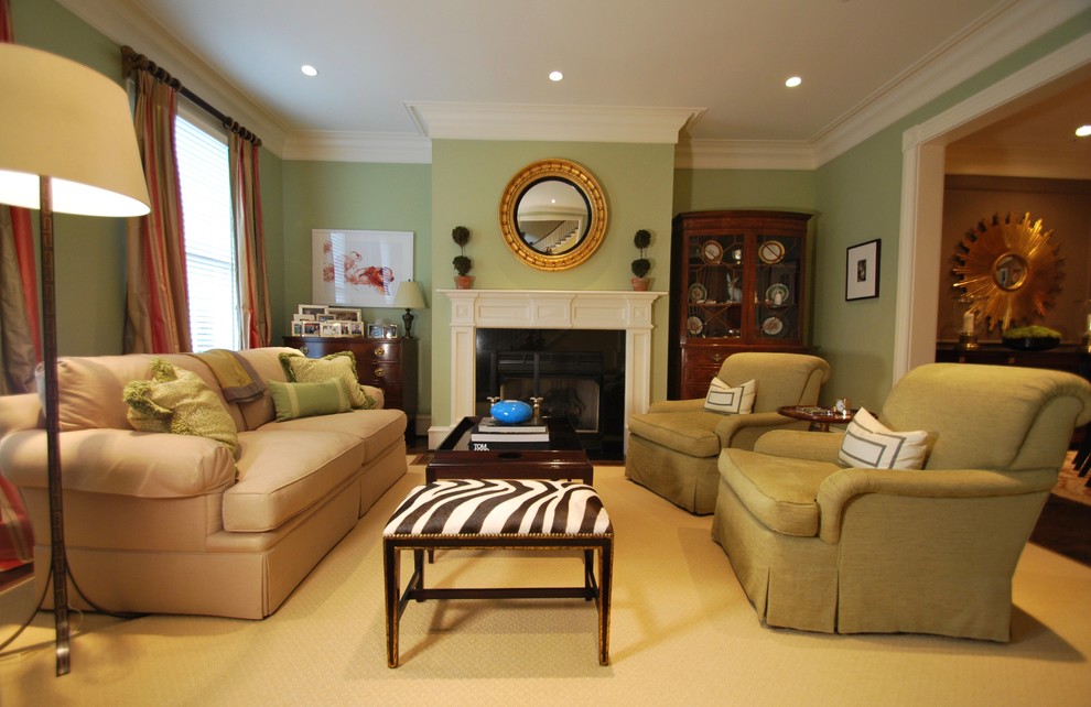 Inredning av ett klassiskt mellanstort separat vardagsrum, med ett finrum, gröna väggar, mörkt trägolv, en standard öppen spis, en spiselkrans i sten och brunt golv