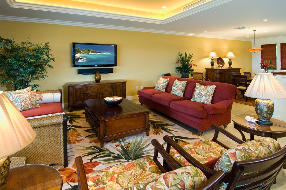 На фото: открытая гостиная комната в морском стиле с желтыми стенами, полом из известняка и телевизором на стене с