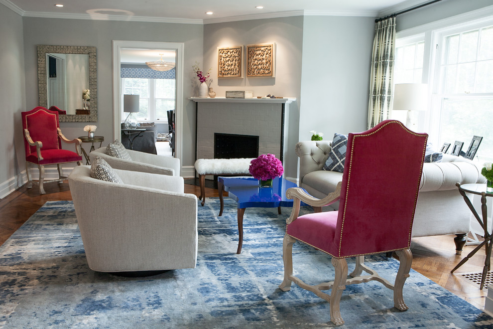 Exemple d'un grand salon chic ouvert avec une salle de réception, un mur bleu, un sol en bois brun, une cheminée standard et un manteau de cheminée en brique.