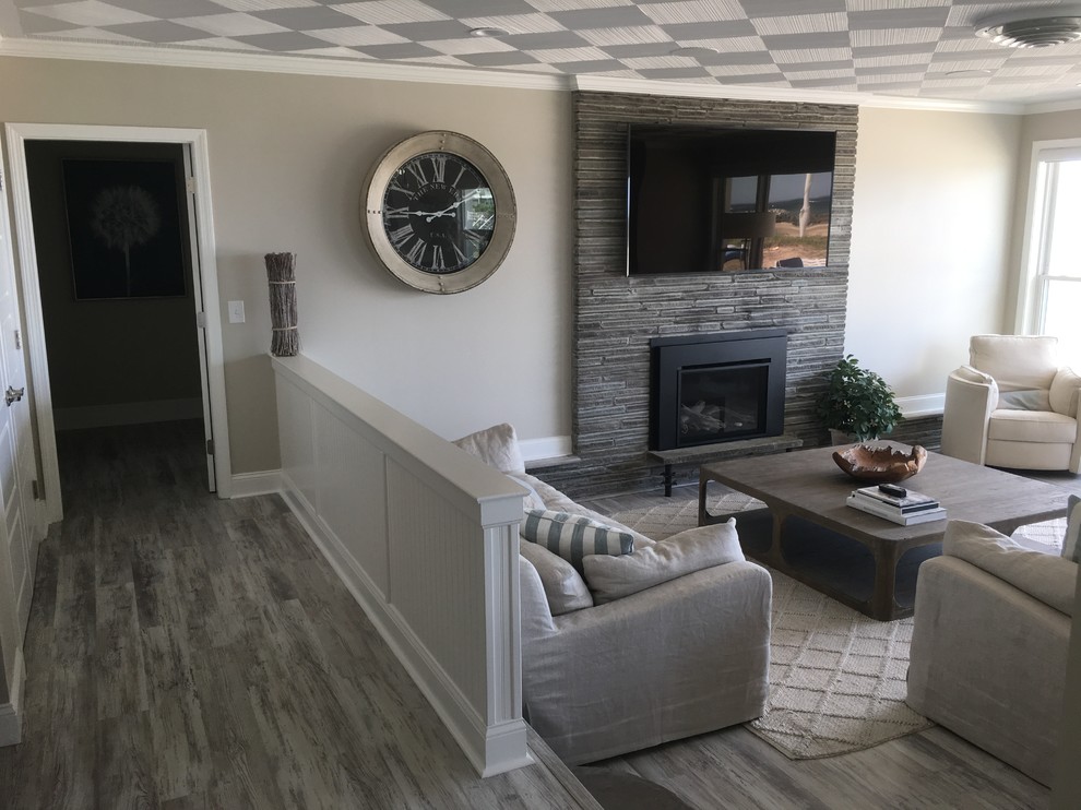 Example of a mid-sized beach style open concept dark wood floor and gray floor living room design in Boston with gray walls, a standard fireplace, a stone fireplace and a wall-mounted tv