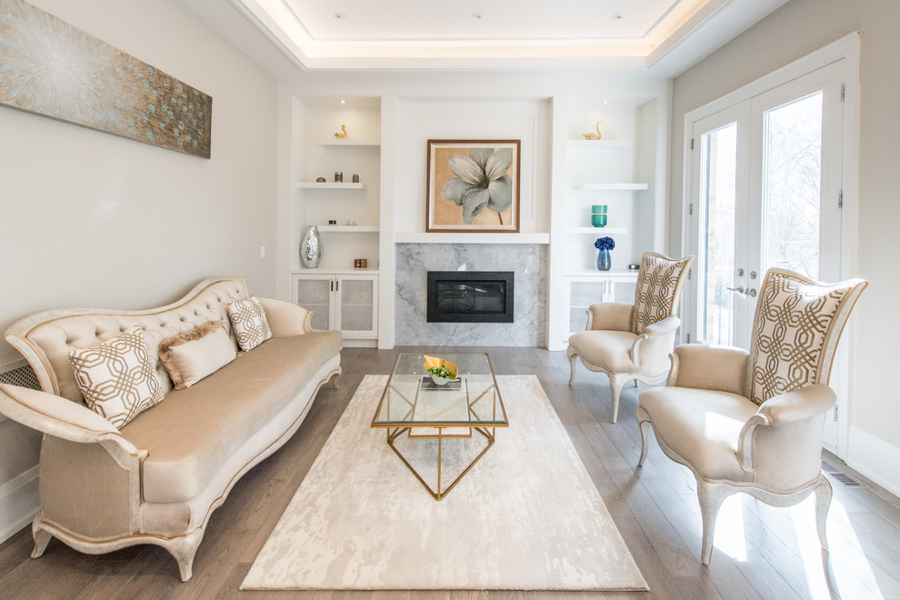Example of a transitional medium tone wood floor and brown floor living room design in Toronto with gray walls, a standard fireplace and a stone fireplace