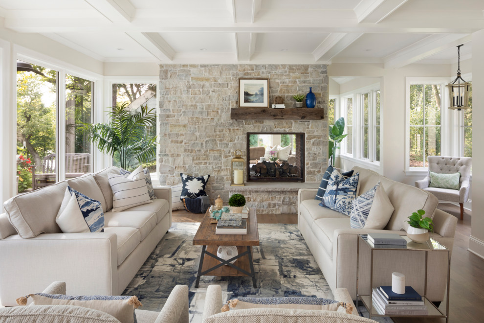 Inspiration for a large classic formal open plan living room in Minneapolis with beige walls, medium hardwood flooring, a two-sided fireplace, a stone fireplace surround and a coffered ceiling.