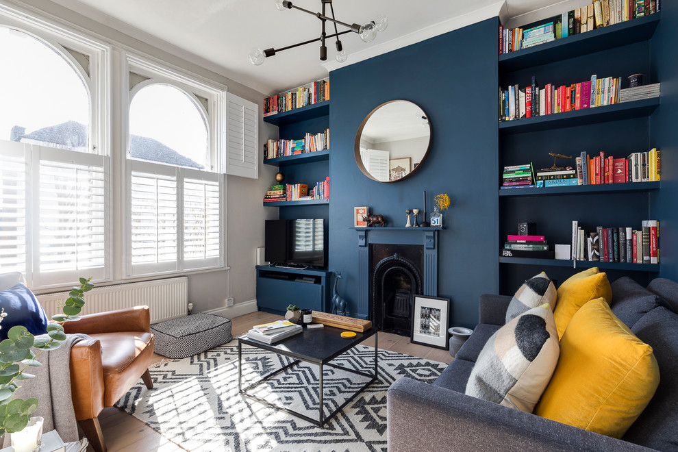 Immagine di un soggiorno chic di medie dimensioni con pareti blu, parquet chiaro, cornice del camino in legno e TV autoportante