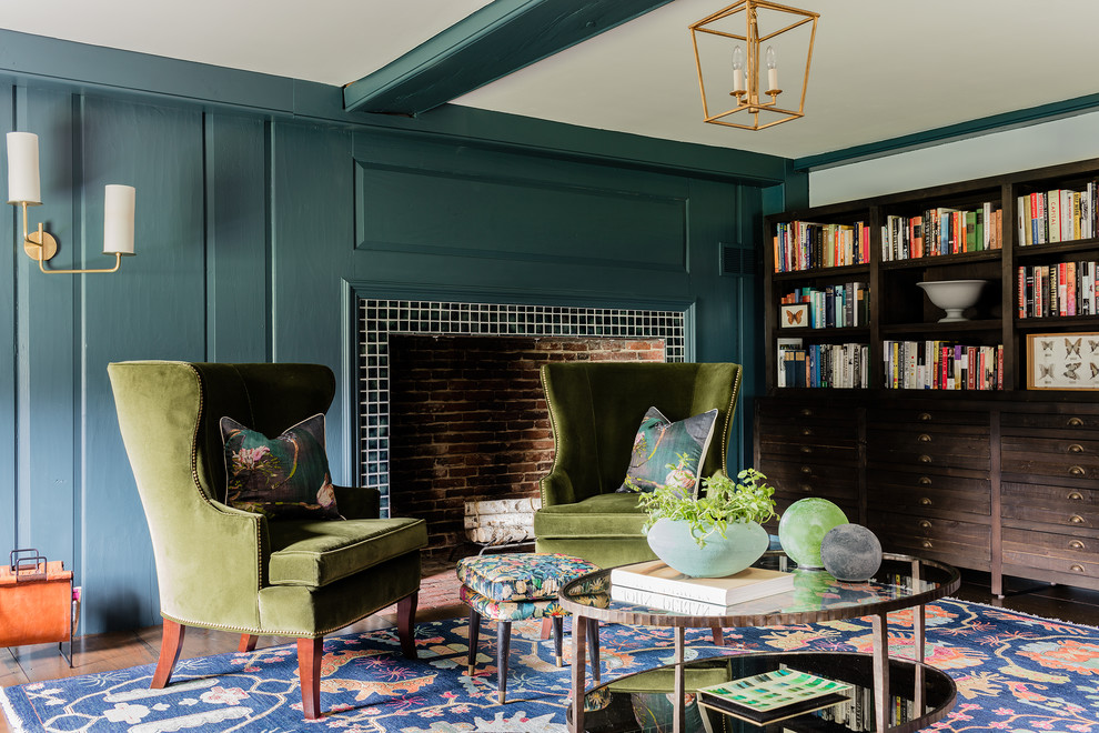 На фото: гостиная комната в стиле неоклассика (современная классика) с зелеными стенами, стандартным камином, фасадом камина из плитки, темным паркетным полом и коричневым полом