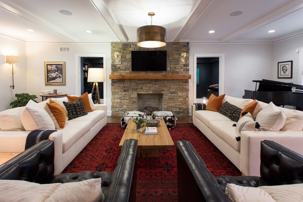 Пример оригинального дизайна: большая парадная гостиная комната в стиле неоклассика (современная классика) с белыми стенами, темным паркетным полом, фасадом камина из камня, телевизором на стене, стандартным камином и коричневым полом