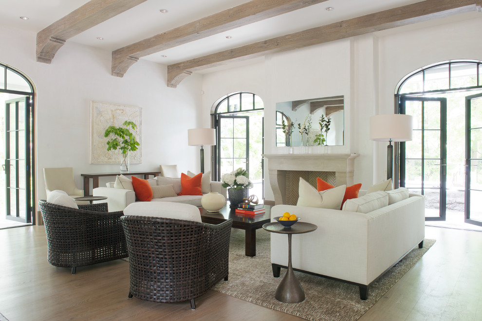 Immagine di un soggiorno chic con sala formale, pareti bianche, camino classico, cornice del camino piastrellata e parquet chiaro