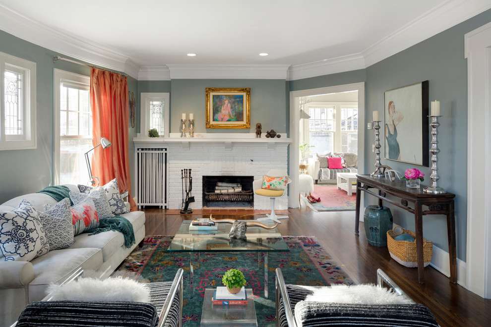 Aménagement d'un salon classique avec un mur bleu, un sol en bois brun, une cheminée standard, un manteau de cheminée en brique et un sol marron.